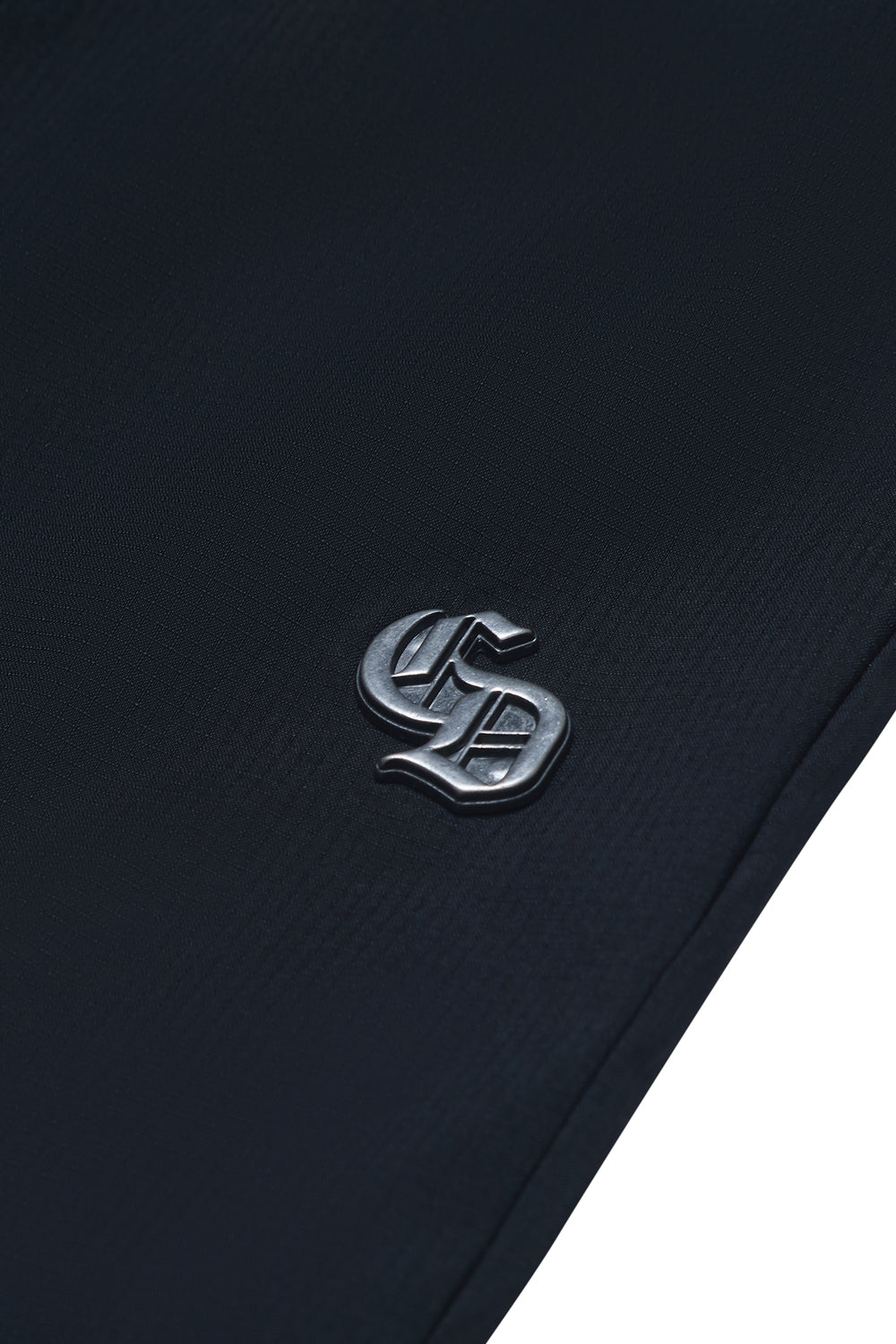 Close up of Criminal Damage branding hardware on white background