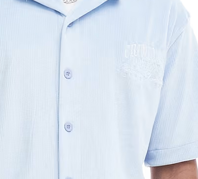 Light blue Criminal Damage striped shirt with a brand logo on a white background