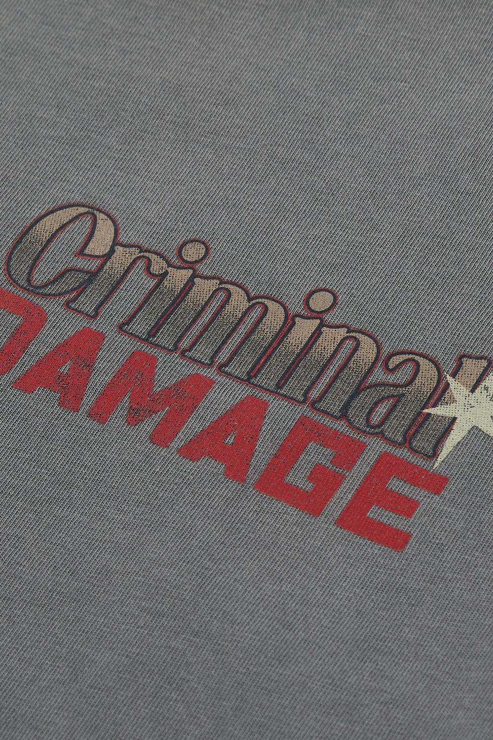 Close up of Criminal Damage branding on grey t-shirt 