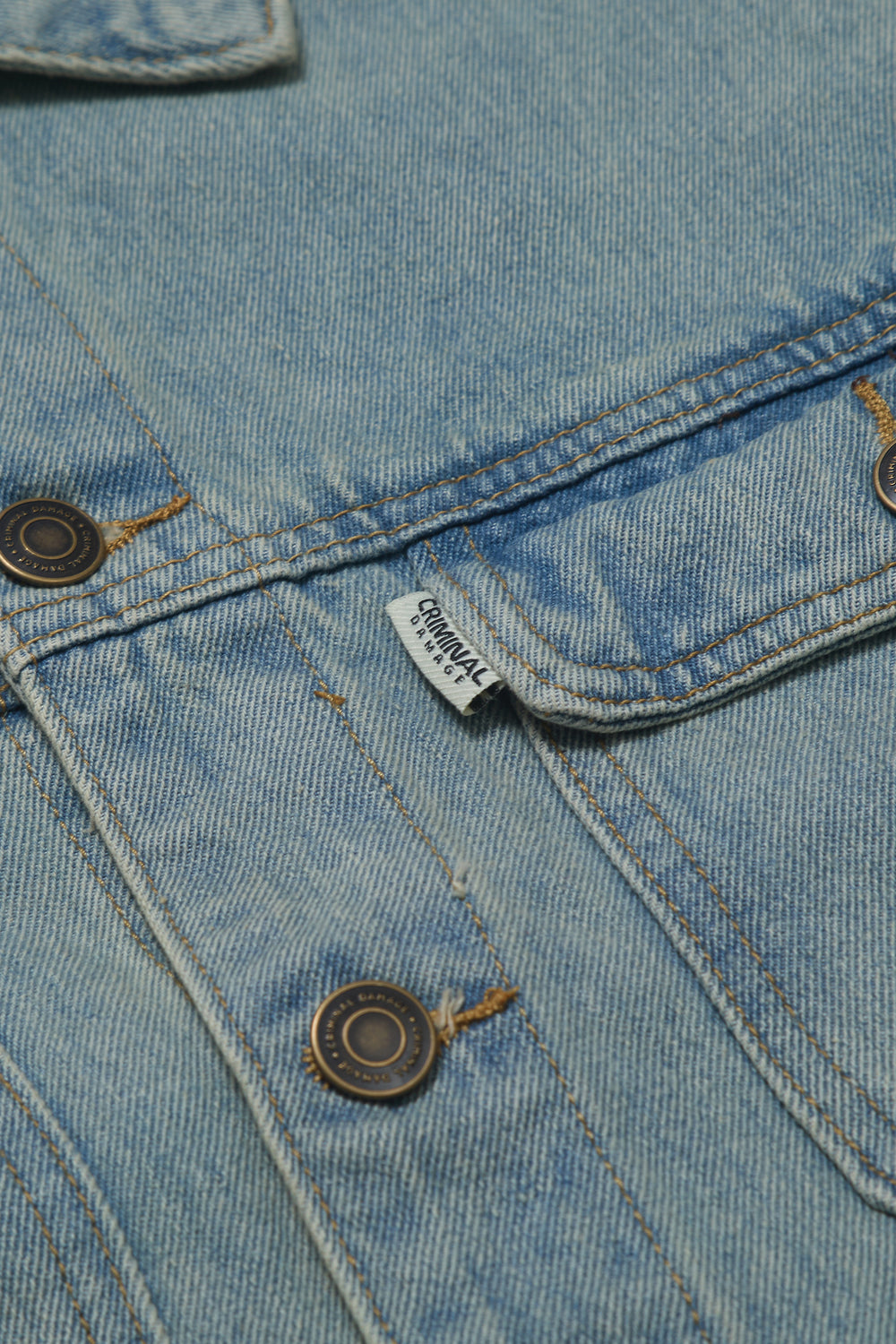 Close up of Criminal Damage denim jacket brand tag and buttons